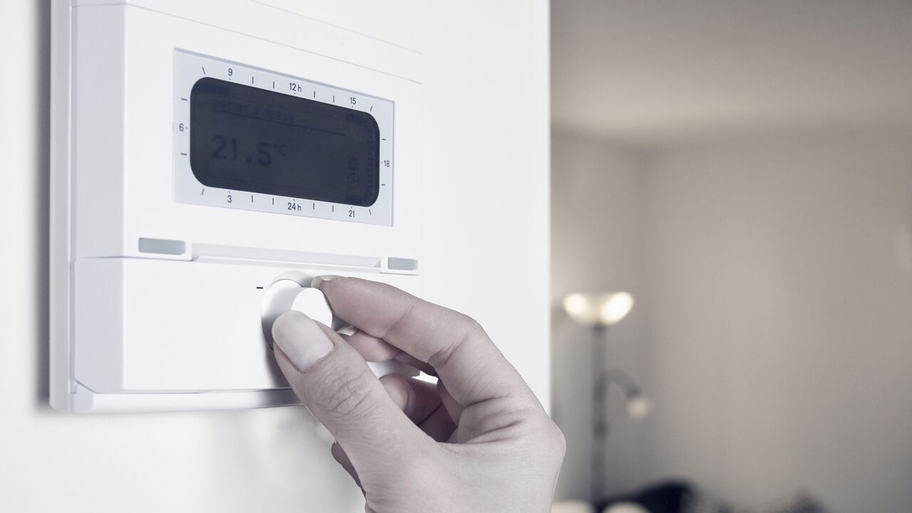 Women's hand adjusting a thermostat